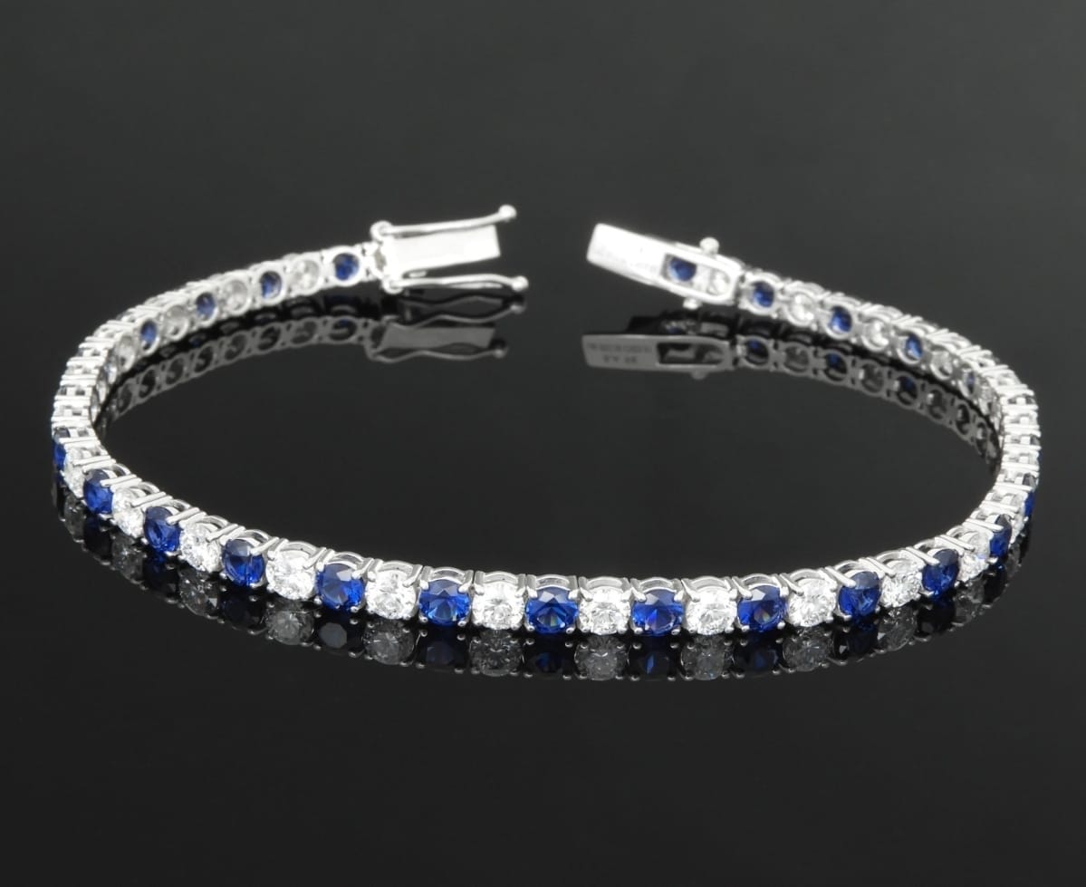 Alternating round blue and clear stones in a classic tennis-bracelet setting, white gold.