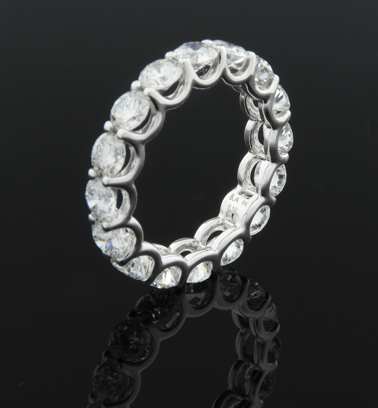 Round brilliant diamonds set continuously around the full band, white gold.