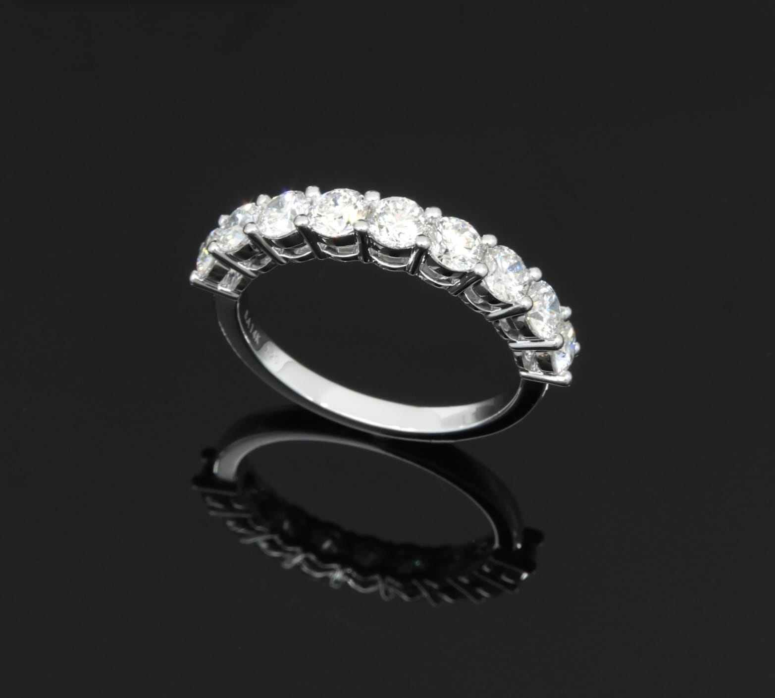 Nine round brilliant diamonds in a classic half-eternity setting, white gold.